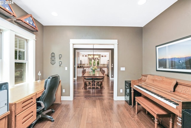 office with hardwood / wood-style flooring and a chandelier