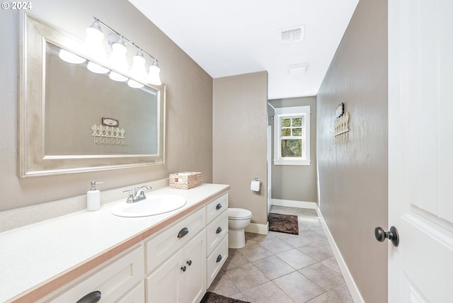 bathroom featuring vanity, toilet, and tile patterned flooring