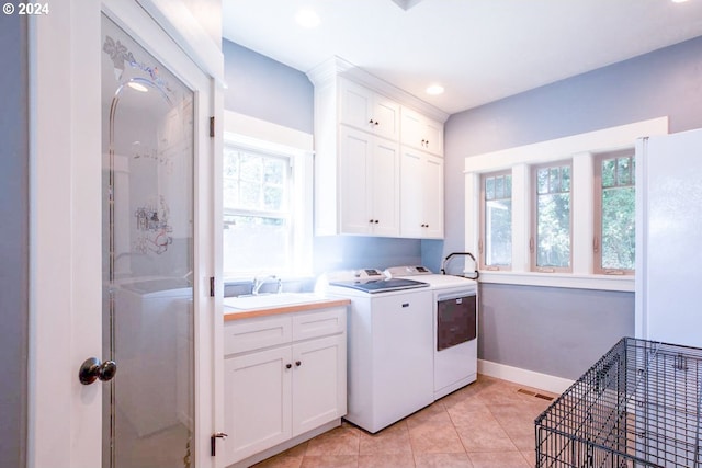 laundry room with sink, independent washer and dryer, light tile patterned floors, and cabinets