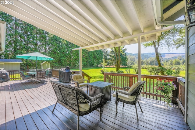 deck with a mountain view and a lawn