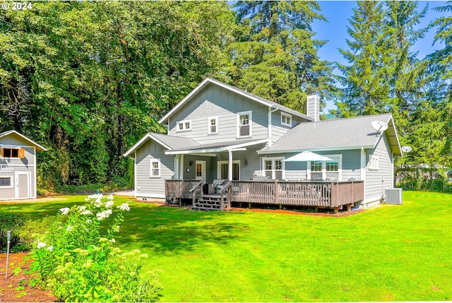 back of house with cooling unit, a storage shed, a deck, and a yard