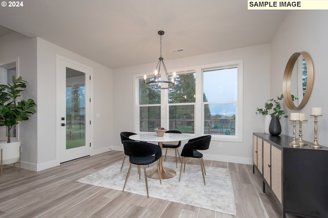 dining space with a notable chandelier, visible vents, baseboards, and light wood-style floors