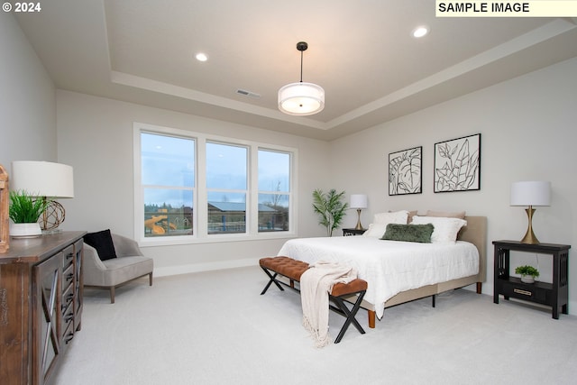 bedroom with light carpet and a tray ceiling