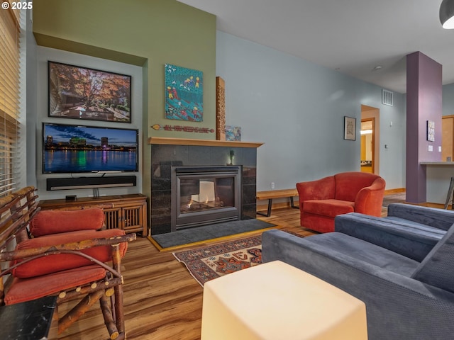 living room featuring hardwood / wood-style flooring and a tiled fireplace