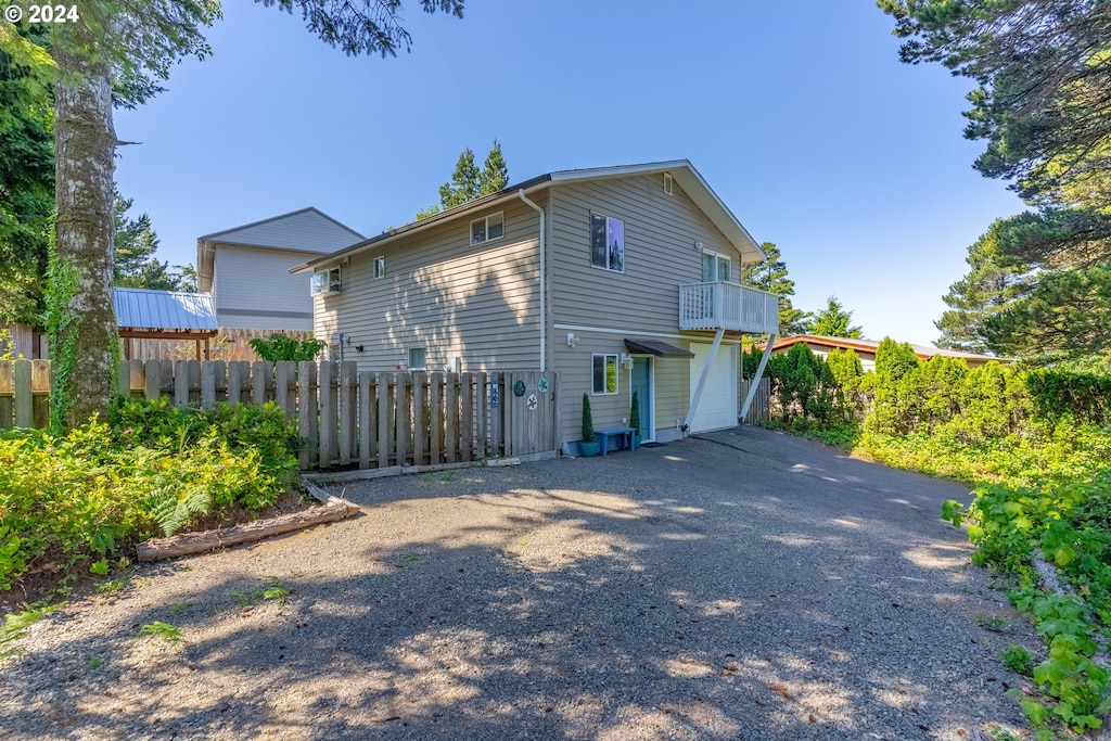 view of side of property featuring a garage and a balcony