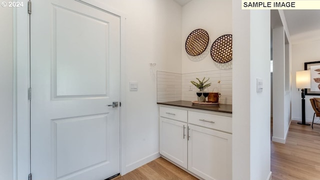 hallway featuring light wood-type flooring and baseboards