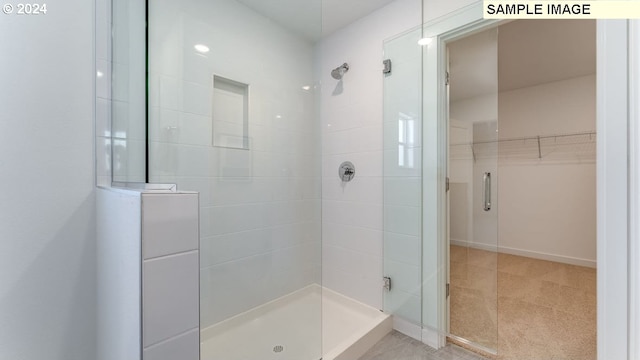 full bathroom featuring a shower stall and a spacious closet