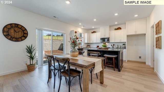 dining space featuring baseboards, light wood-type flooring, and recessed lighting