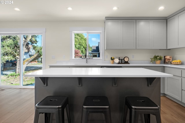 kitchen featuring a kitchen breakfast bar, gray cabinetry, and light hardwood / wood-style floors