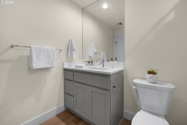 bathroom with vanity, toilet, and wood-type flooring