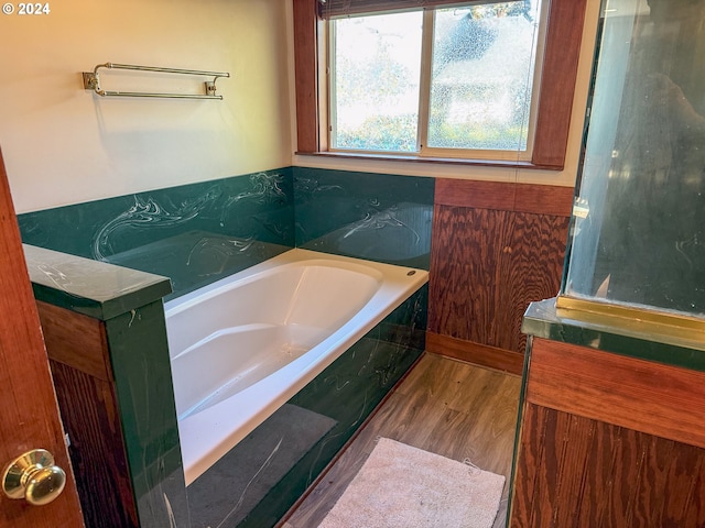 bathroom with a bath and hardwood / wood-style floors