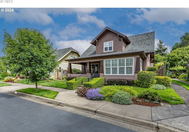 craftsman-style home featuring covered porch and a front yard