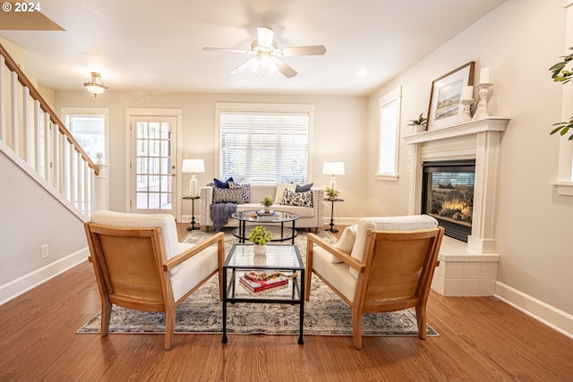 living room featuring a tile fireplace, wood-type flooring, and plenty of natural light