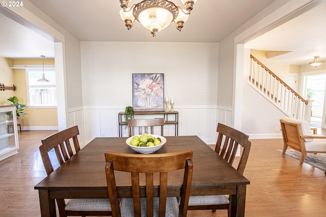 dining room with hardwood / wood-style floors and an inviting chandelier