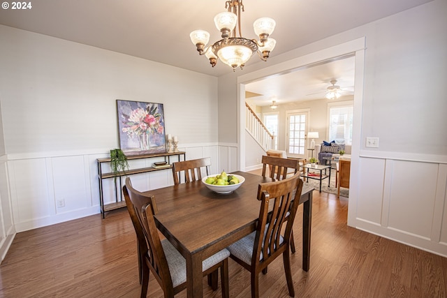 dining space with dark wood-type flooring and ceiling fan with notable chandelier