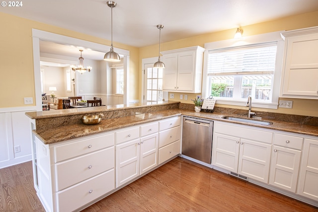 kitchen with stainless steel dishwasher, white cabinetry, kitchen peninsula, and sink