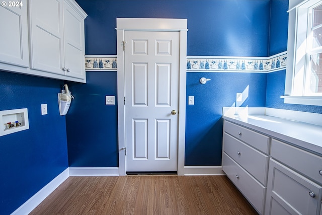 washroom with cabinets, hookup for a washing machine, and dark wood-type flooring