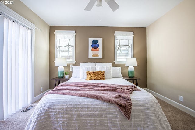 bedroom with multiple windows, ceiling fan, and carpet