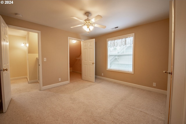 unfurnished bedroom with ceiling fan and light colored carpet