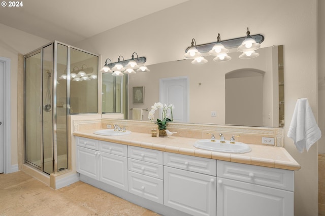 bathroom featuring double vanity, tile patterned floors, a sink, and a shower stall