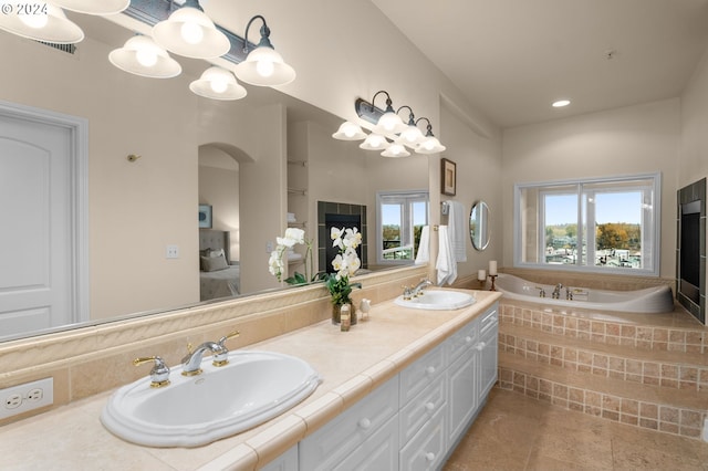 bathroom featuring a wealth of natural light, a sink, and ensuite bathroom