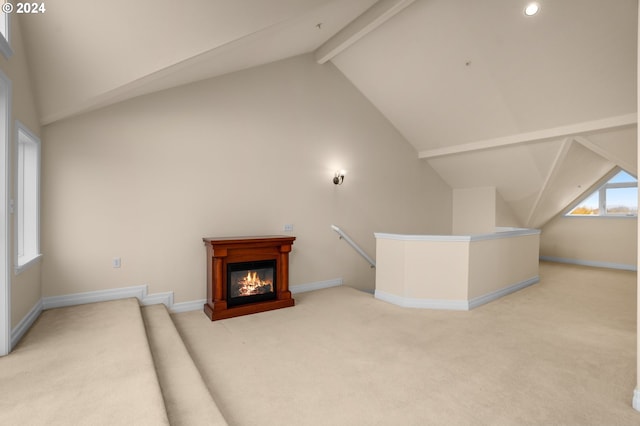 additional living space featuring high vaulted ceiling, light colored carpet, beamed ceiling, and baseboards