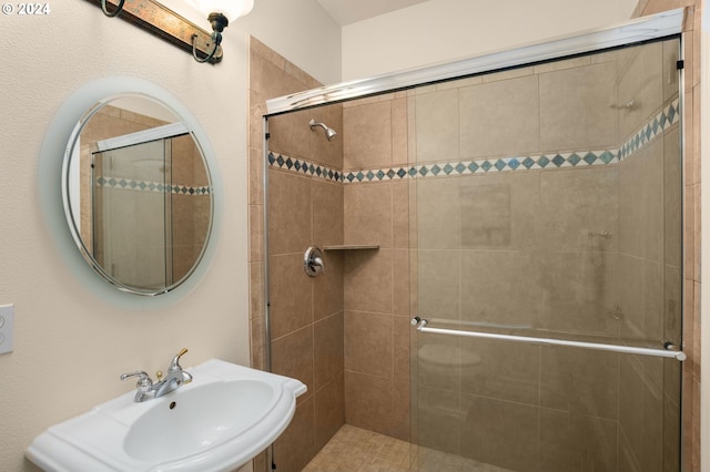 full bathroom featuring a stall shower and a sink