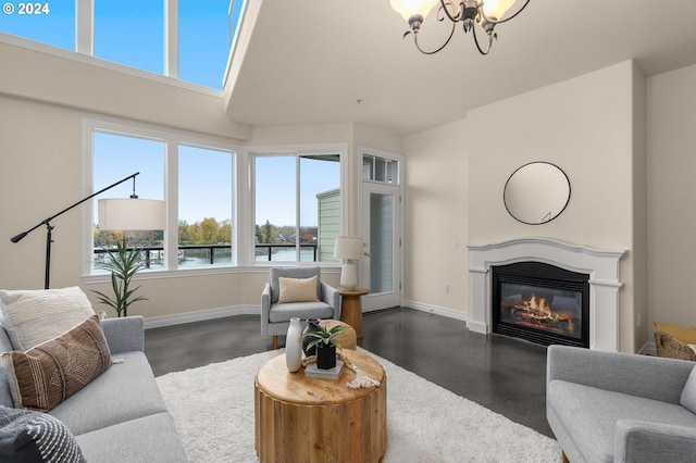 living room with baseboards, a chandelier, and a glass covered fireplace