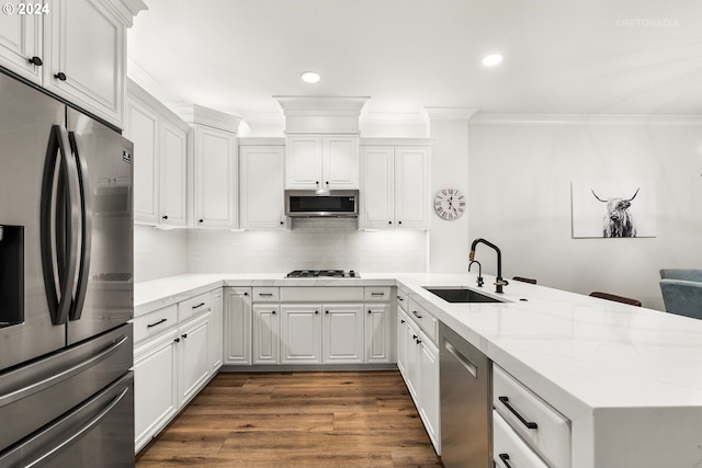 kitchen featuring sink, tasteful backsplash, kitchen peninsula, stainless steel appliances, and white cabinets