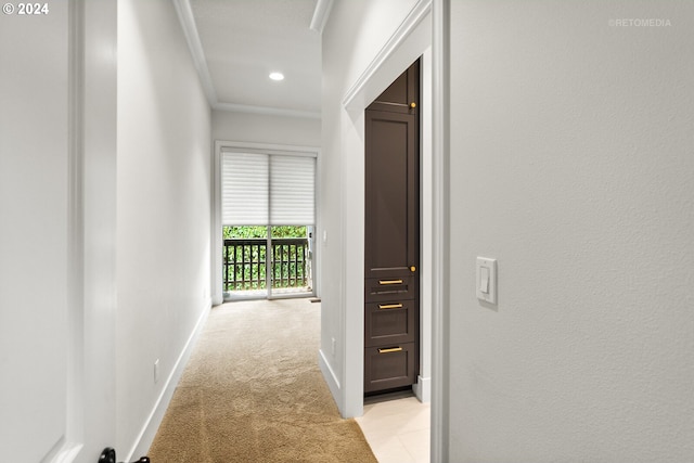 hall with ornamental molding and light colored carpet