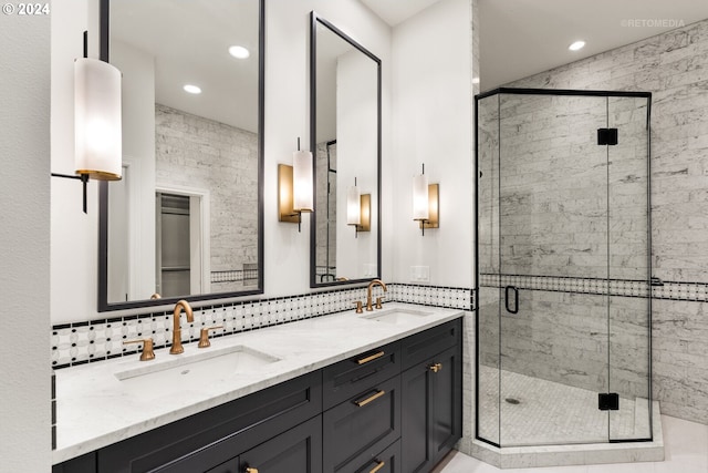 bathroom featuring a shower with door, vanity, and backsplash