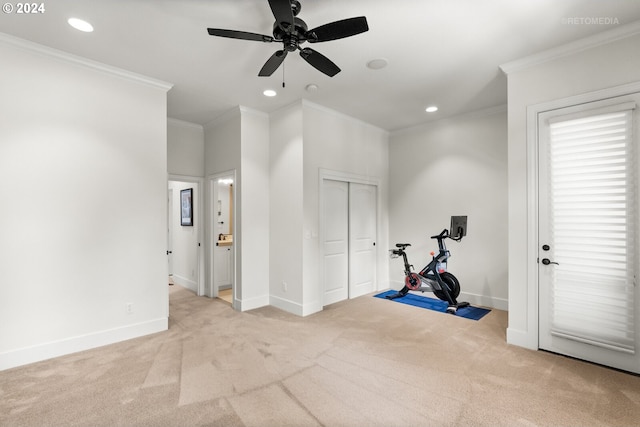 workout area featuring crown molding, light carpet, and ceiling fan