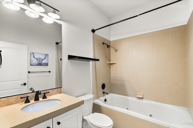 full bathroom featuring vanity, tiled shower / bath combo, and toilet