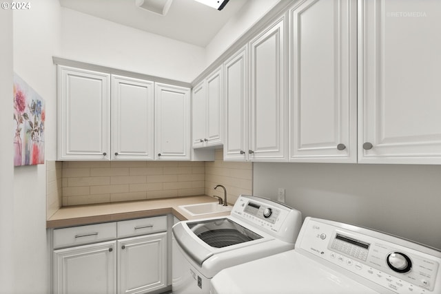 washroom featuring sink, cabinets, and washing machine and clothes dryer