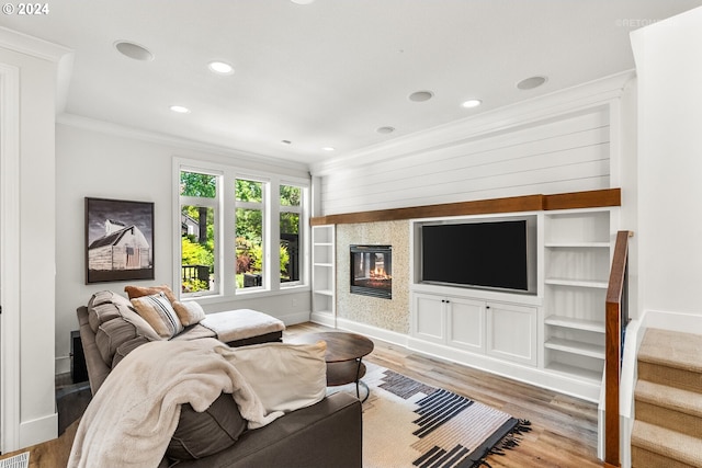 living room featuring hardwood / wood-style flooring, ornamental molding, and built in features