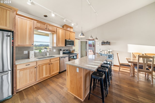 kitchen featuring sink, a center island, stainless steel appliances, dark hardwood / wood-style flooring, and backsplash