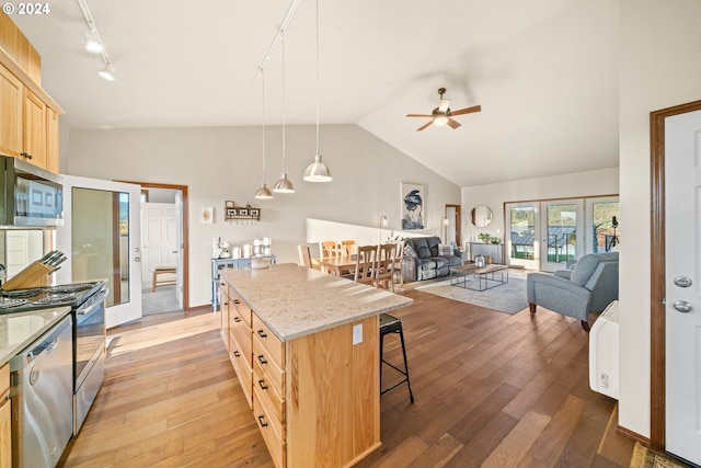 kitchen with french doors, light hardwood / wood-style floors, decorative light fixtures, light brown cabinetry, and appliances with stainless steel finishes