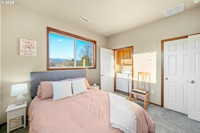 carpeted bedroom with washing machine and dryer