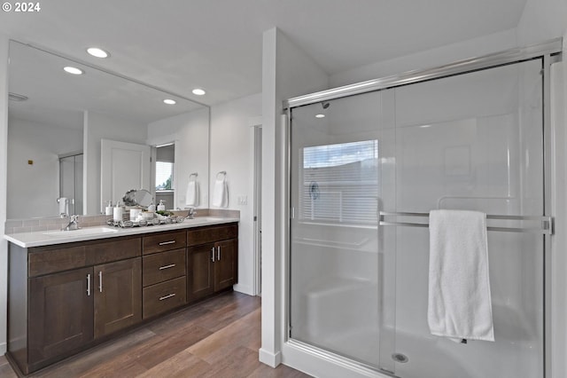 bathroom with walk in shower, hardwood / wood-style flooring, and vanity