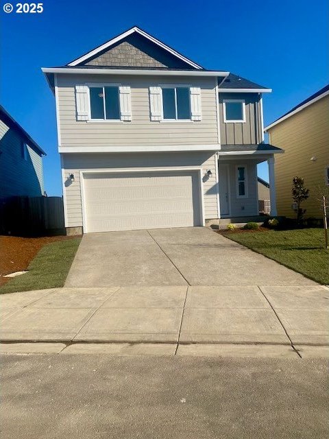 view of front of house featuring a garage, concrete driveway, a front lawn, and board and batten siding