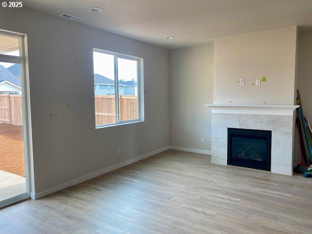 unfurnished living room with recessed lighting, a fireplace, wood finished floors, visible vents, and baseboards