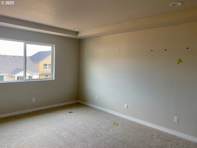 empty room with a textured ceiling, baseboards, and carpet flooring