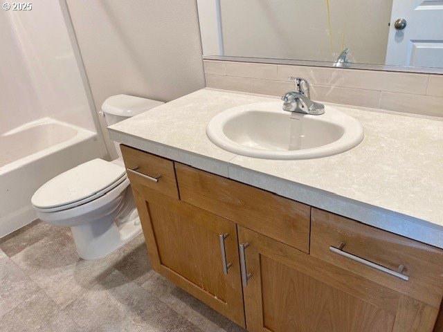 full bathroom with vanity, toilet, and decorative backsplash