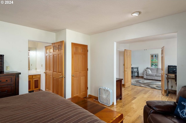 bedroom with a textured ceiling and light hardwood / wood-style flooring