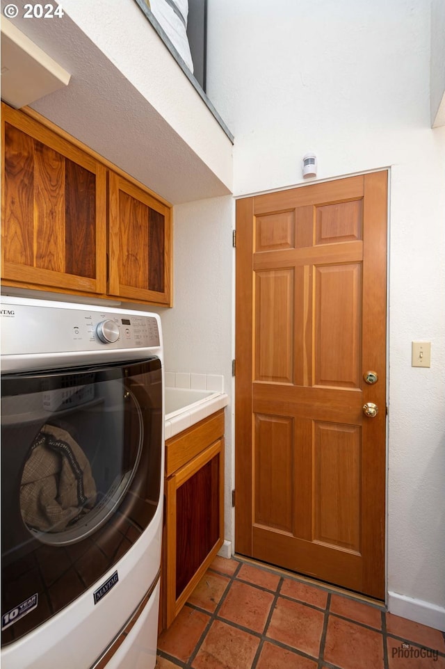 washroom featuring cabinets, washer / dryer, and light tile patterned floors