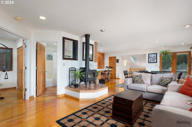 living room with light hardwood / wood-style floors and a wood stove