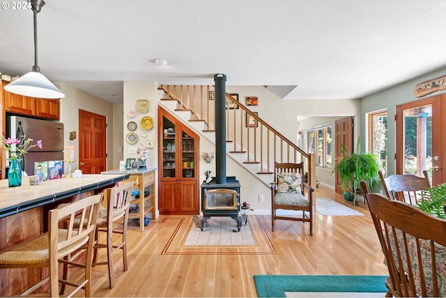 interior space with light hardwood / wood-style floors and a wood stove