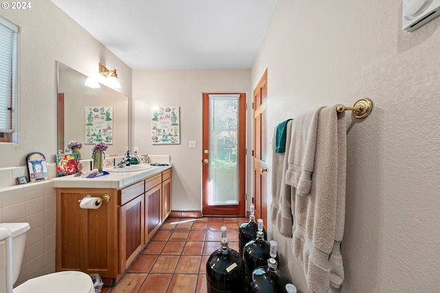 bathroom with tile patterned floors, toilet, vanity, and an AC wall unit