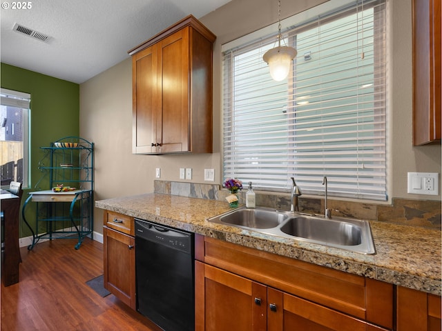 kitchen with pendant lighting, sink, black dishwasher, a textured ceiling, and dark hardwood / wood-style flooring