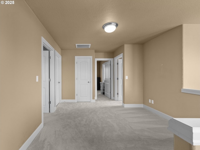 carpeted empty room featuring a textured ceiling